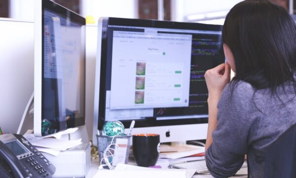 woman working at desk two two monitors