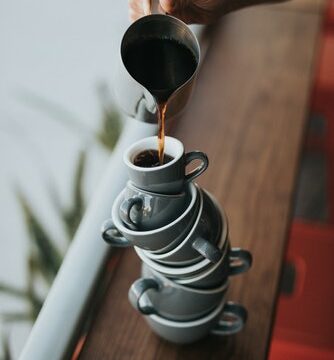 coffee being poured into stacked coffee cups