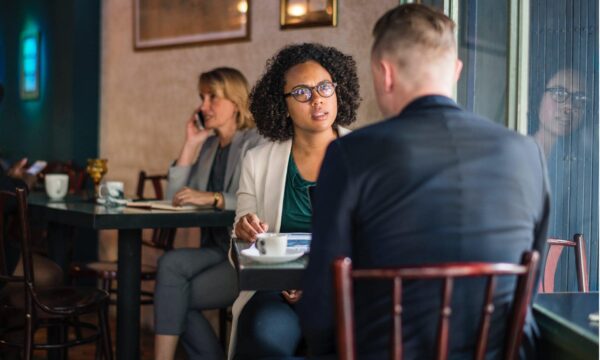 two people at cafe table talking