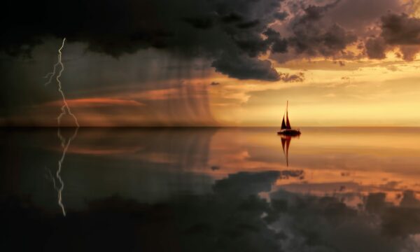silhouette-photography-of-boat-on-water-during-sunset