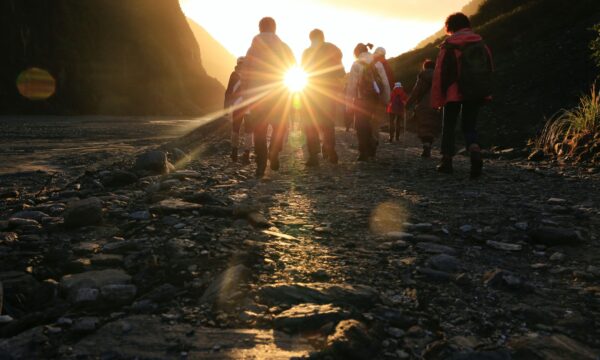 group hiking with sun in the background