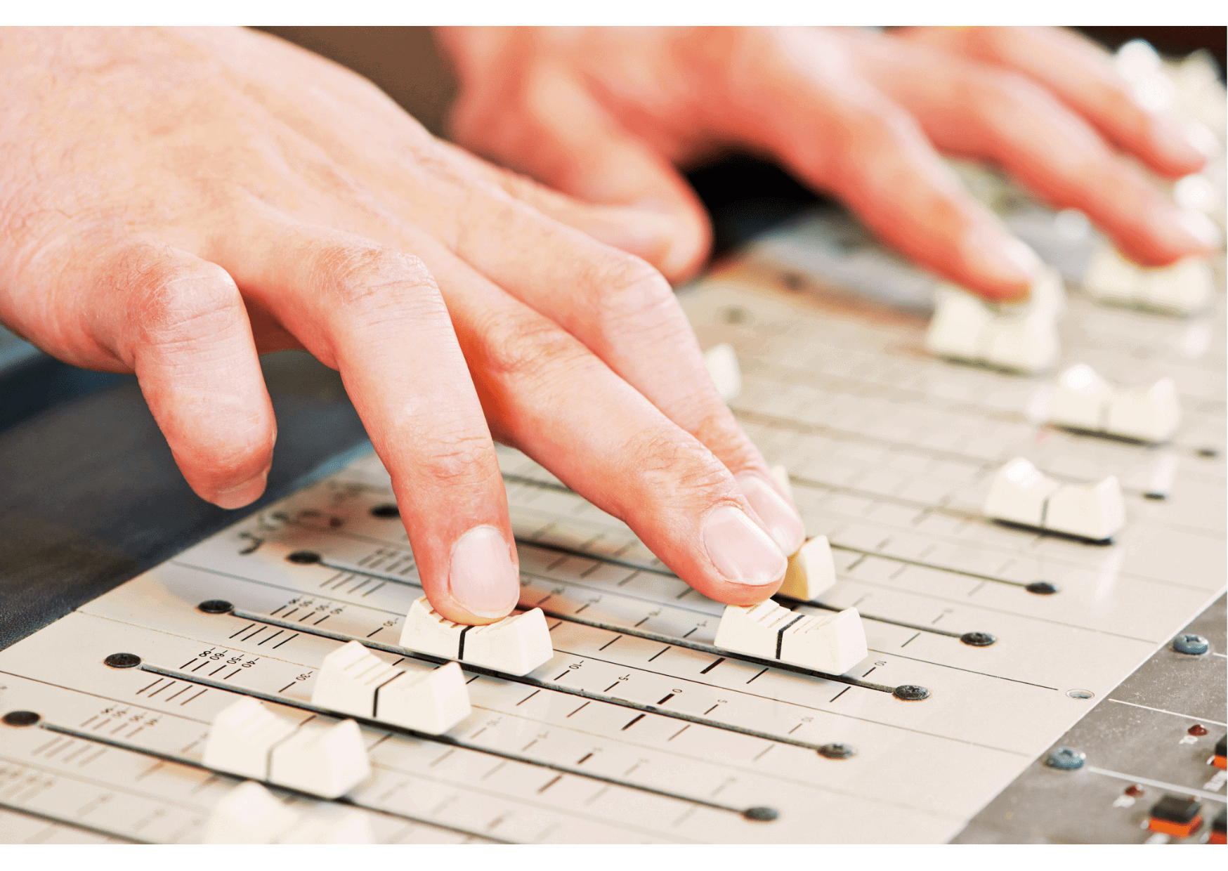 Two hands adjusting white sliding buttons on a sound mixing board