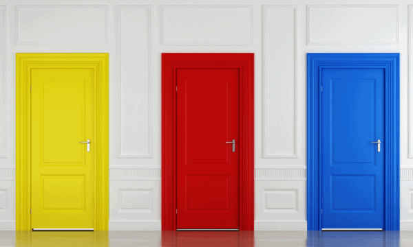Photo of white wall with three doors set into it: bright yellow on the left, true red in the center, and sky-blue on the right
